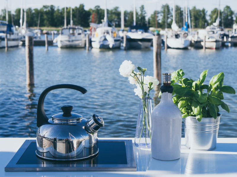 Teepannu keraamisella Wallas-liedellä ja veneitä satamassa